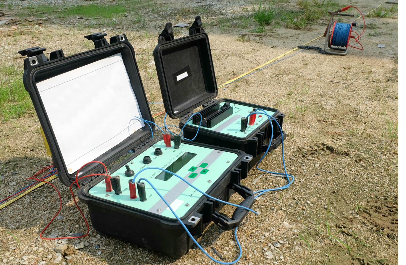 Earth resistivity meter set up in the field with cable reel and test leads